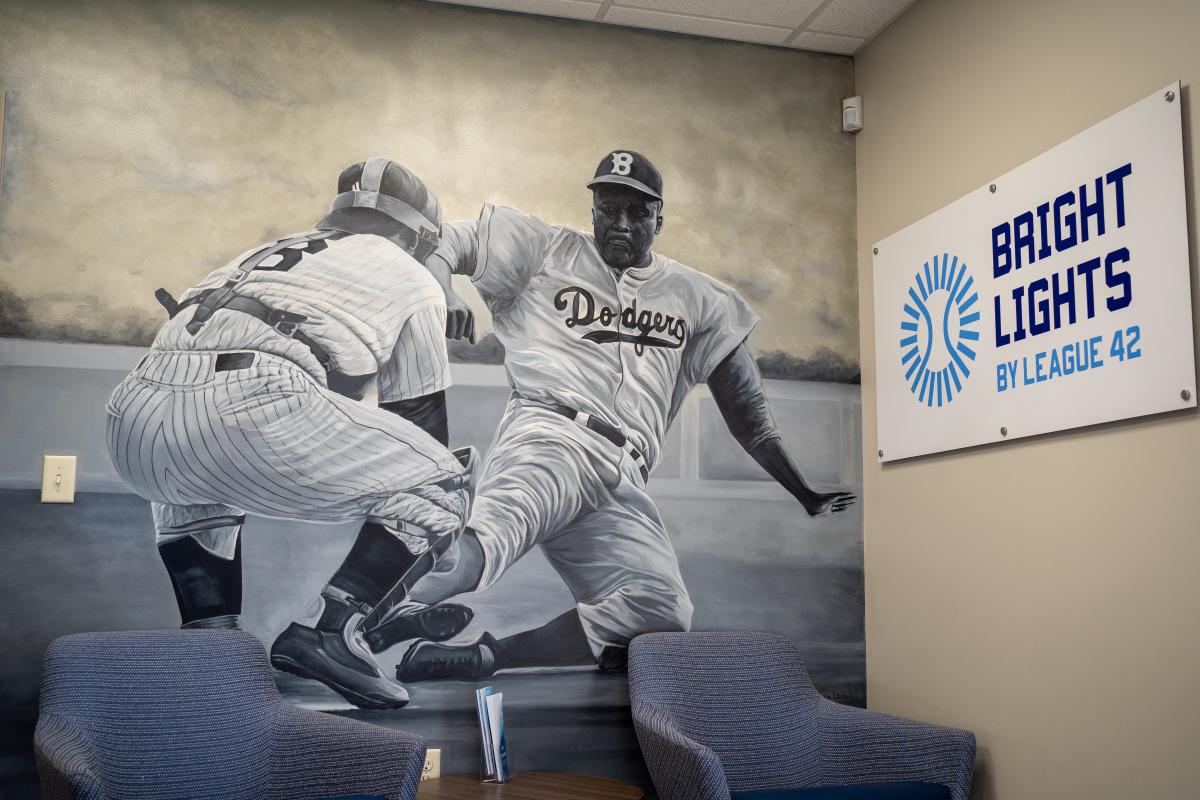 A photo of Jackie Robinson sliding into a base during a game is affixed to a wall at League 42
