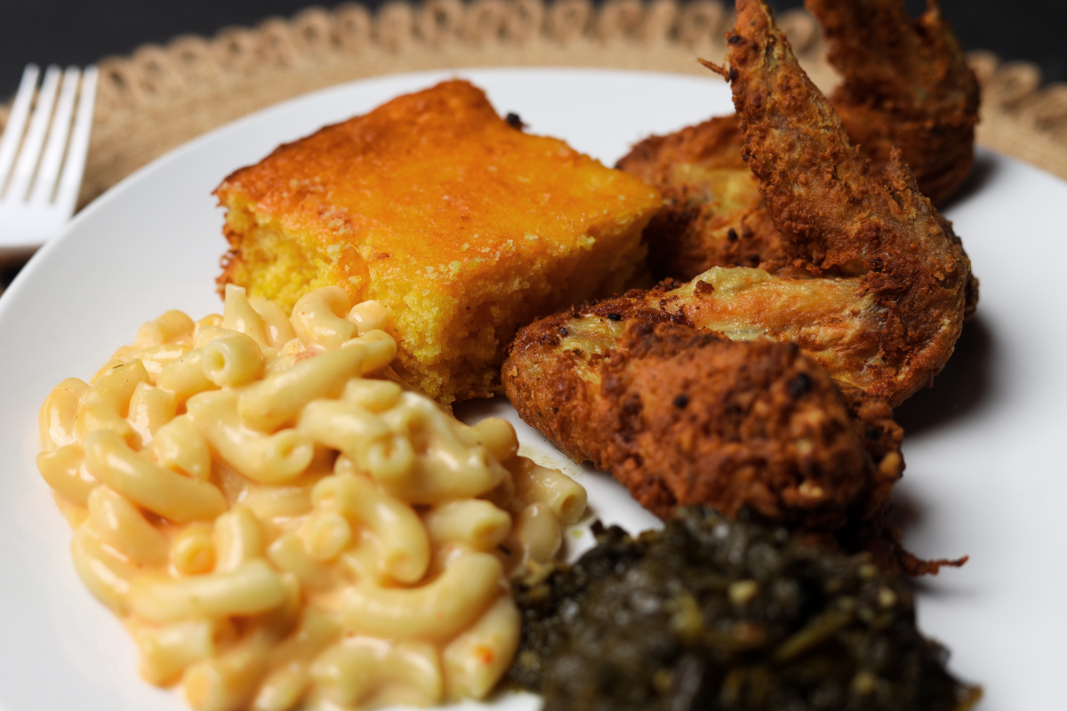 A plate filled with fried chicken, macaroni and cheese, collard greens and corn bread is served at Quita B's in Wichita