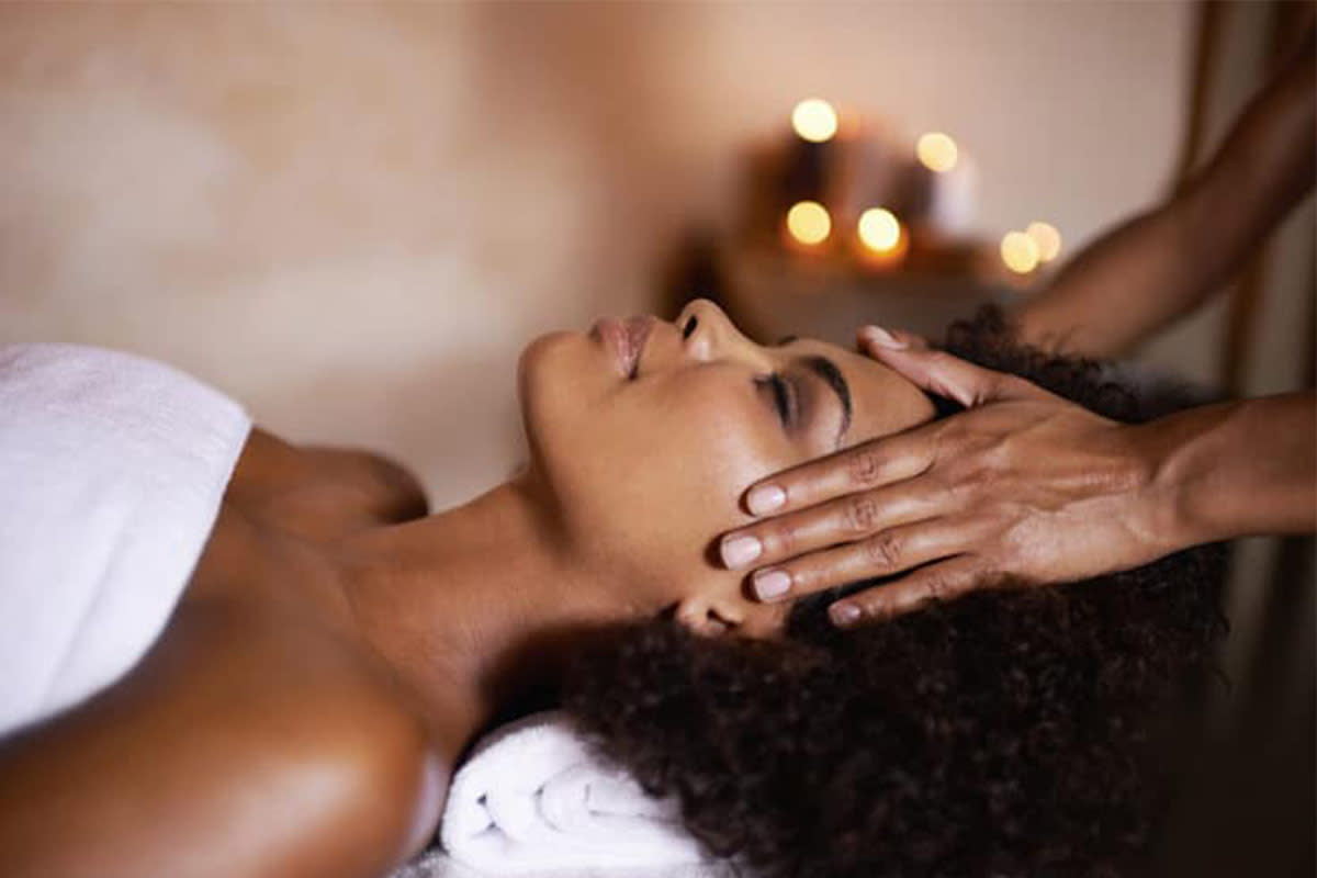 A woman relaxes while getting a face massage at A. Jay Health and Wellness