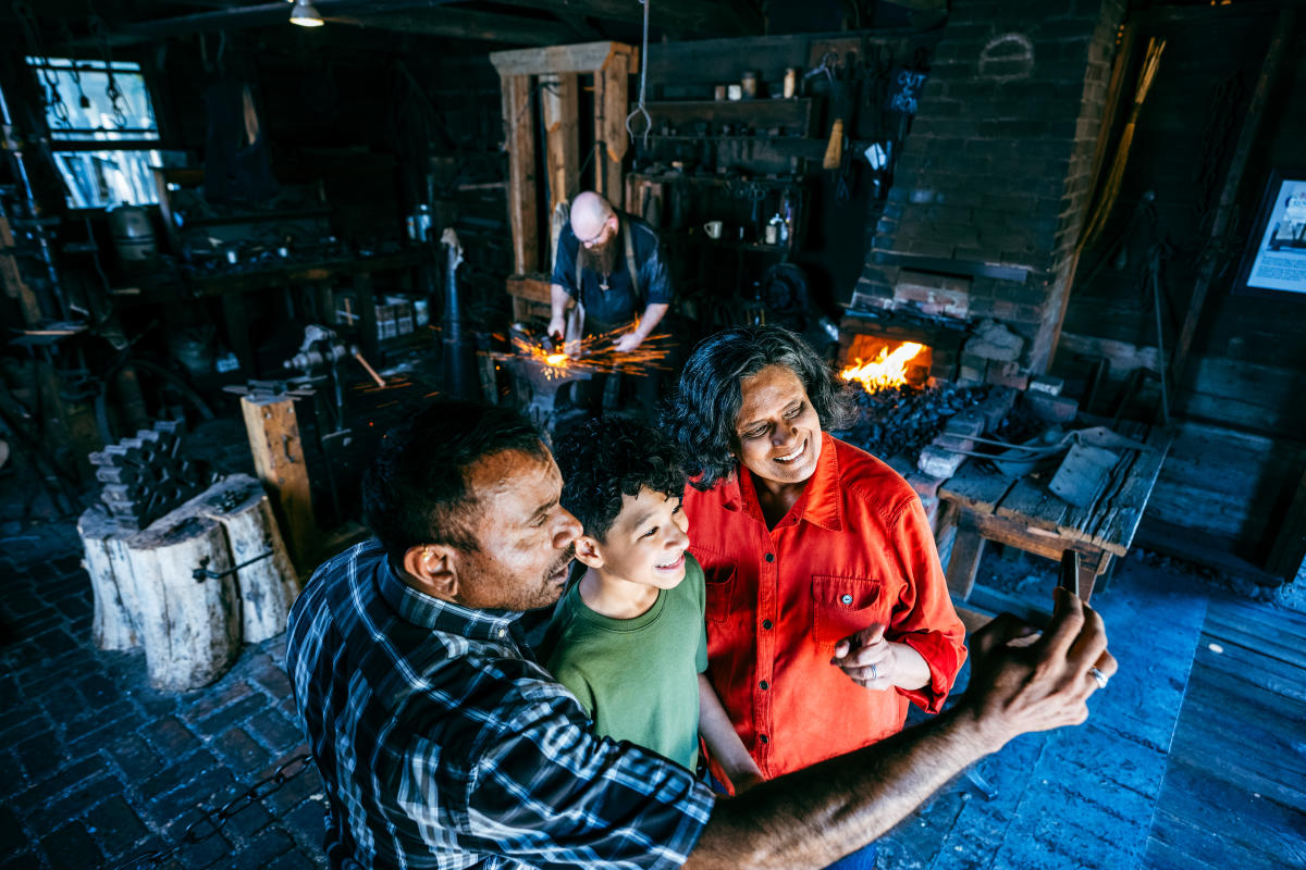 A man, woman and child pose for a selfie at the Blacksmith at Old Cowtown Museum.