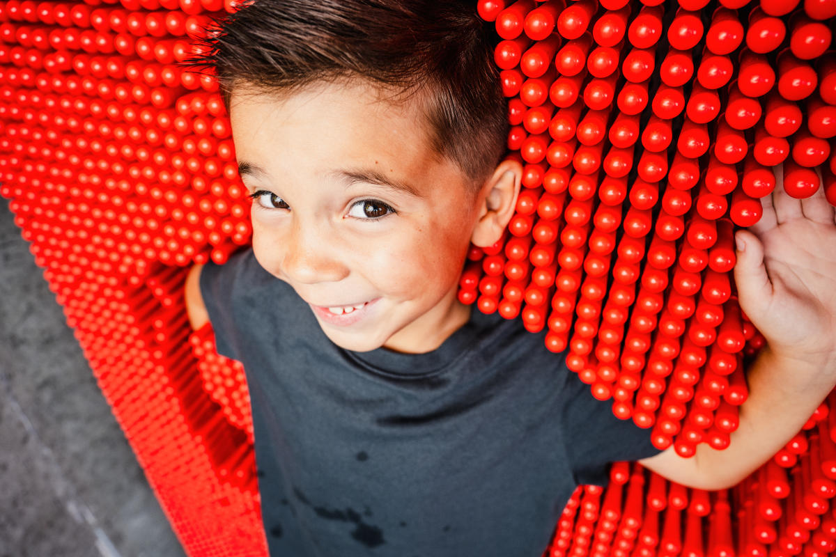 A boy smiles while enjoying an exhibit at Exploration Place