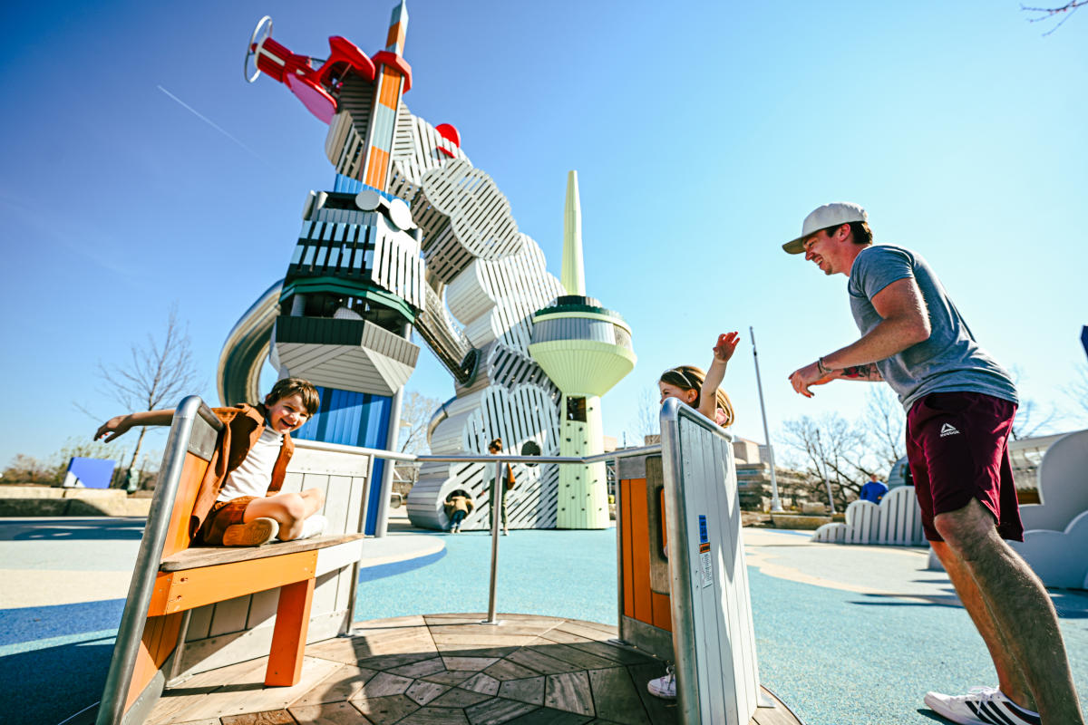 A family plays at the Adventure Playscape outside Exporation Place