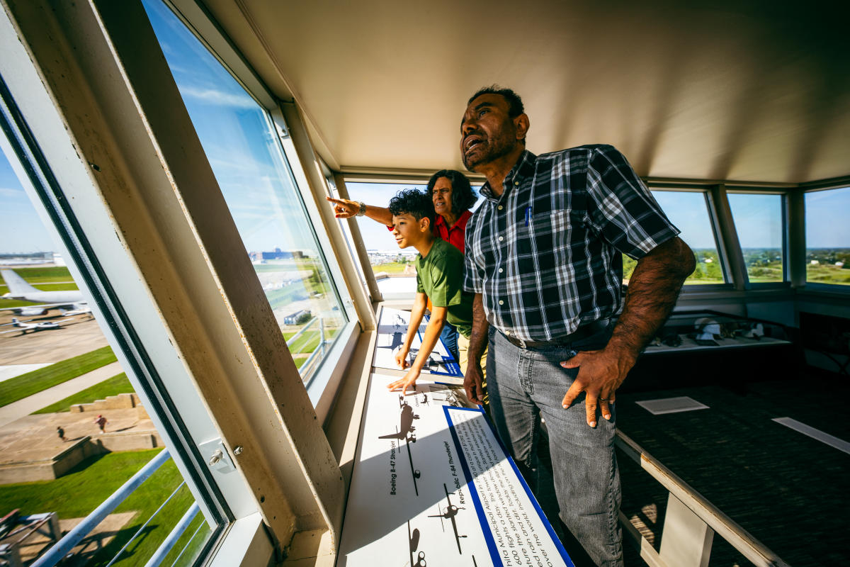 A family enjoys the view of the tarmac from the tower at the Kansas Aviation Museum