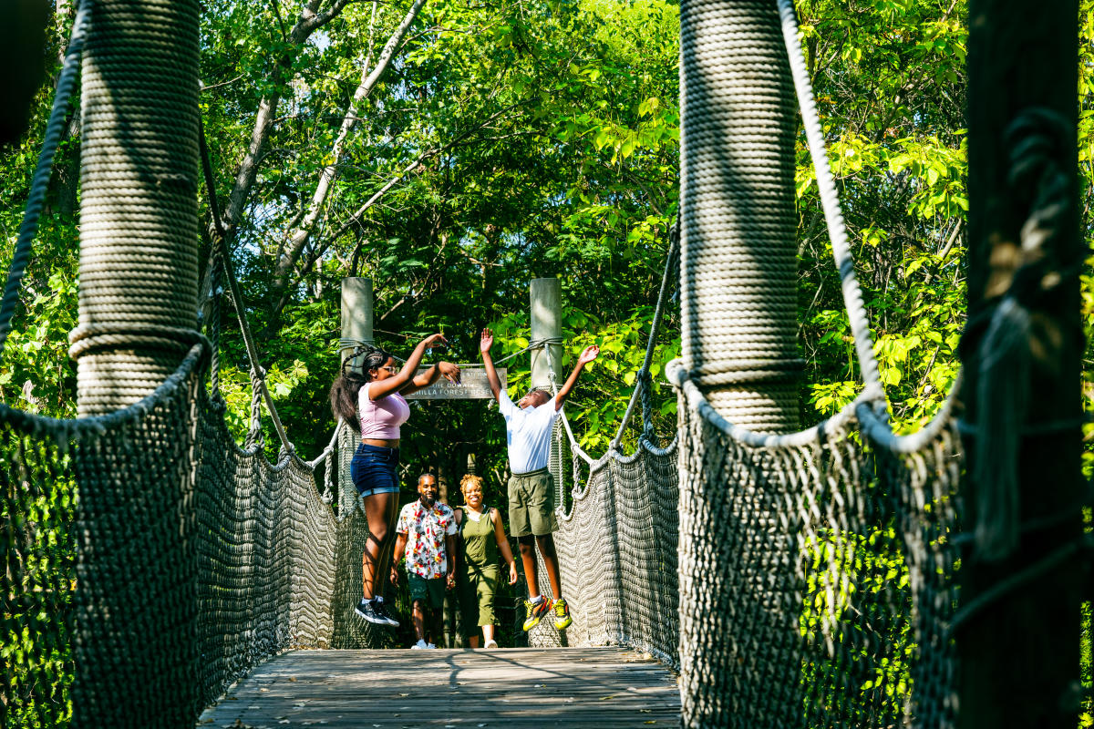 A family jumps on the bridge at the Sedgwick County Zoo.