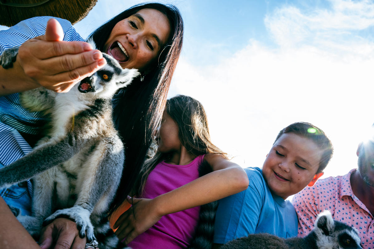 A family smiles while feeding a lemur at Tanganyika Wildlife Park in Wichita.