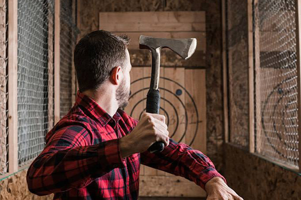 A man prepares to throw an axe at a target at Blade and Timber in Wichita