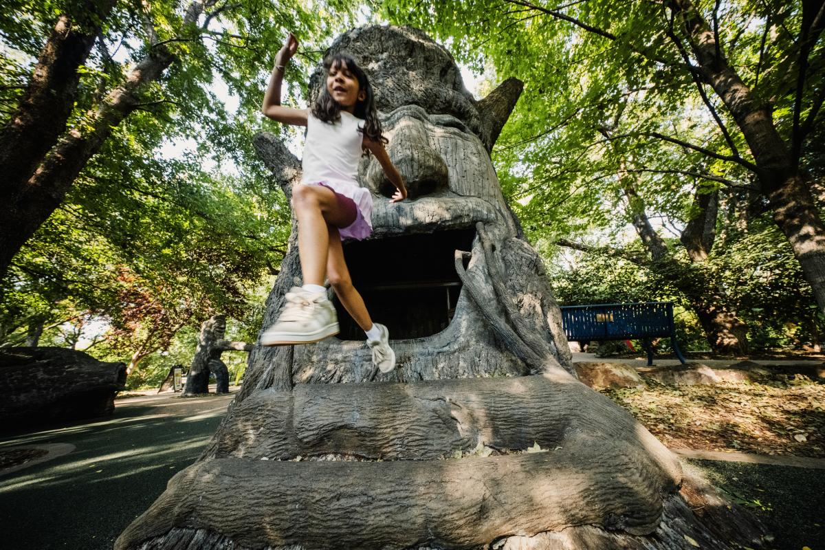 A girl leaps out of the treehouse at Botanica Wichita.