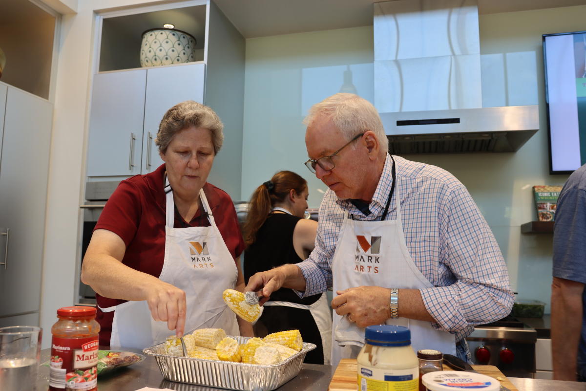 A man and woman make a dish at a cooking class at Mark Arts in Wichita.