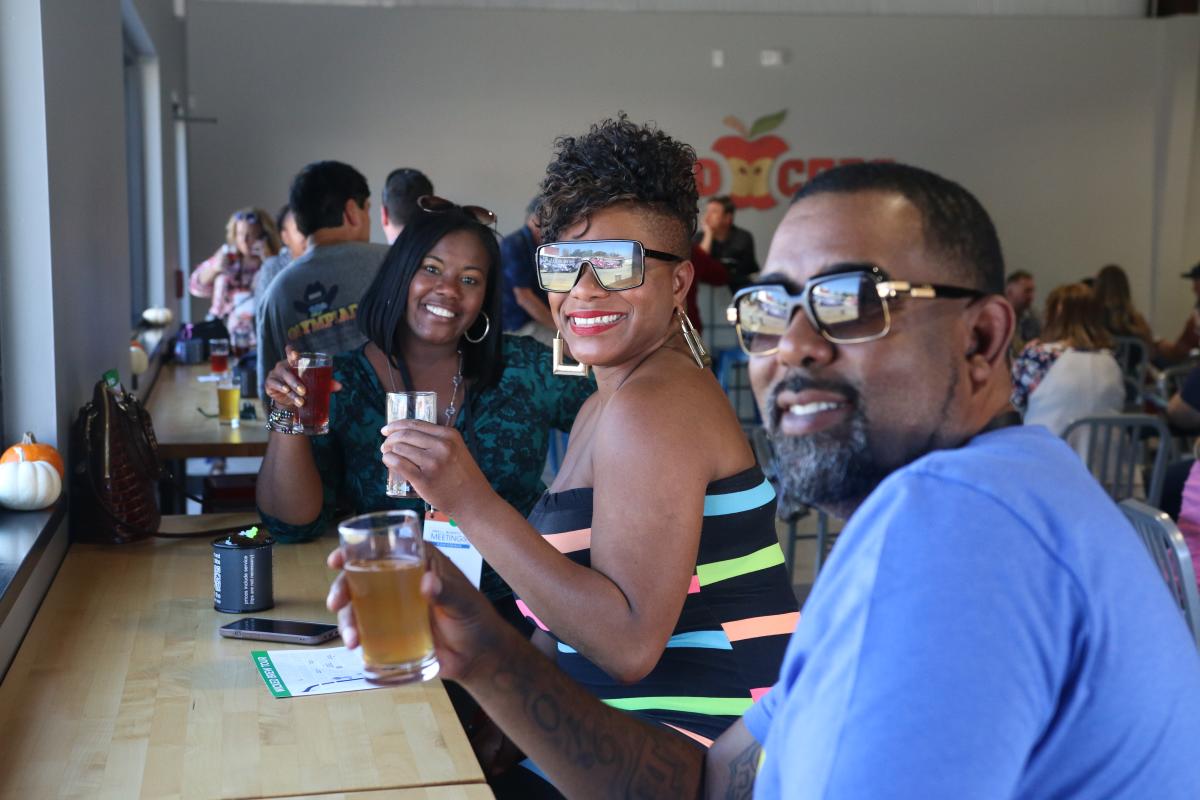 A group of adults enjoy cider at White Crow Cider Company