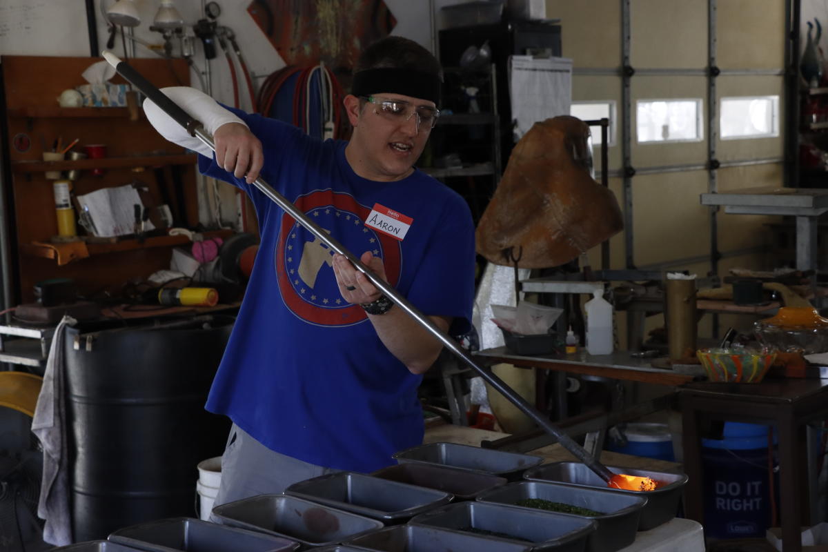 A man demonstrates the art of glass blowing