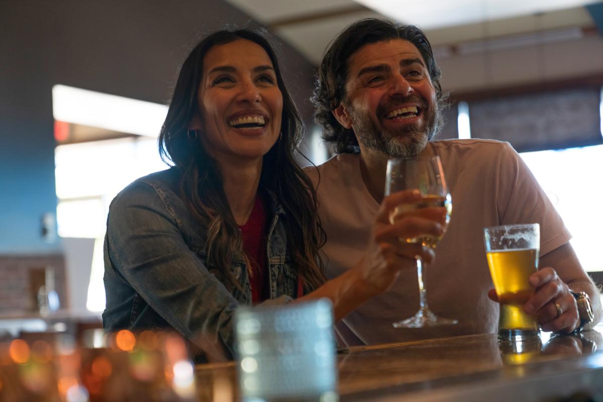 A couple smiles with their drinks at the bar at Newport Grill in Wichita, KS