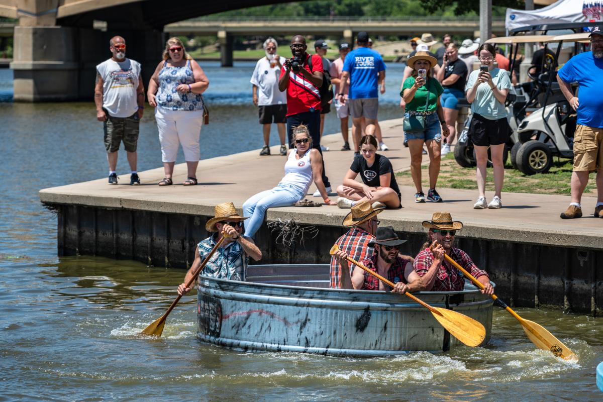 Men paddle on the Arkansas River in a horse trough during the bathtub races at Riverfest.