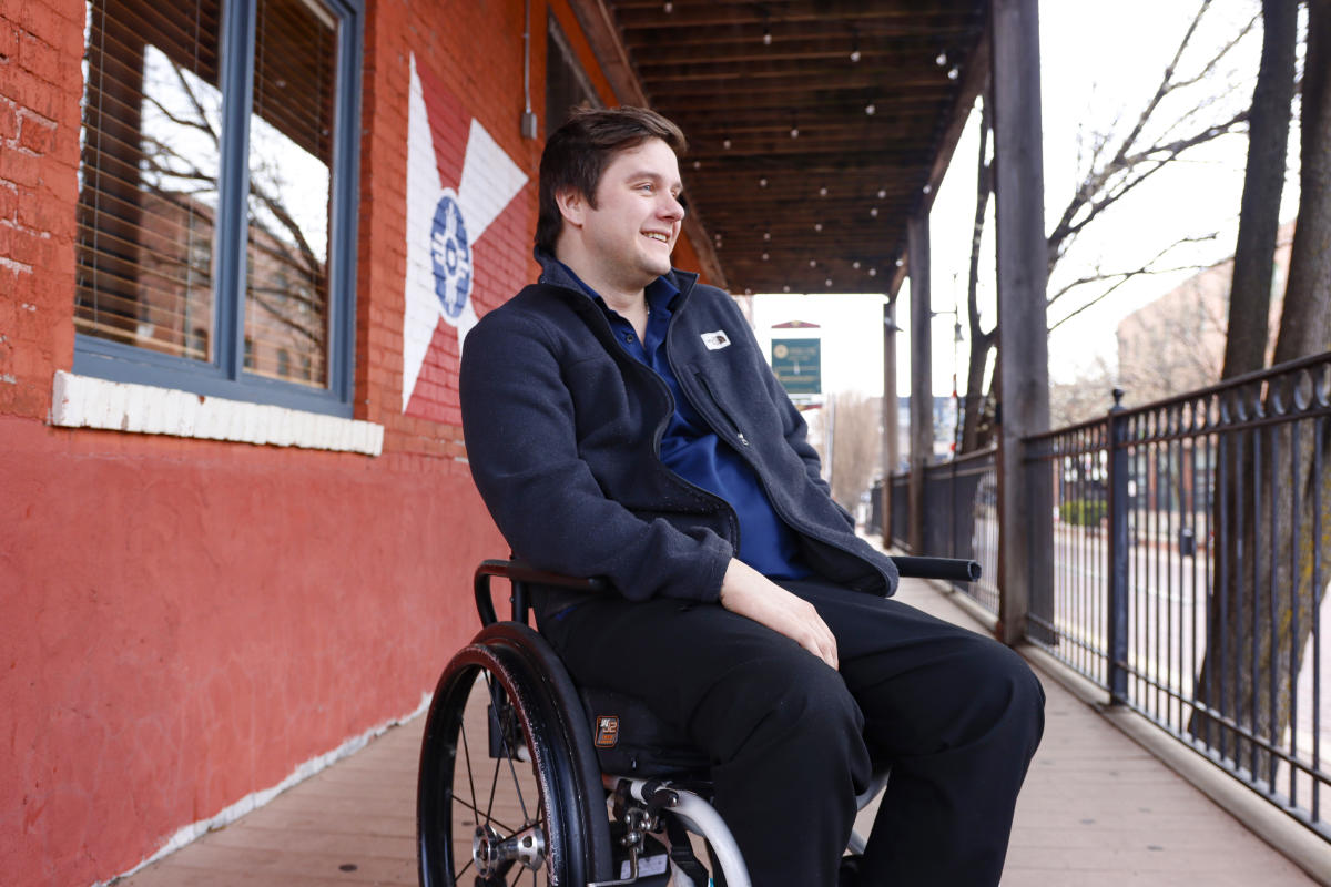 Hunter Vance sits in his wheelchair outside on the porch of River City Brewery in Wichita