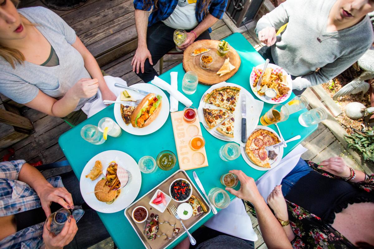 A group enjoys a meal on the patio at Public