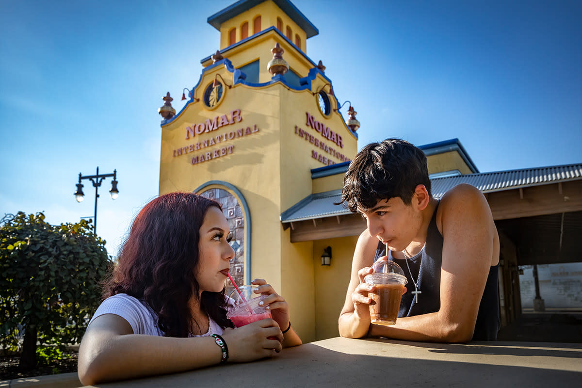 A young Hispanic couple sips on their drinks in the NOMAR International Market