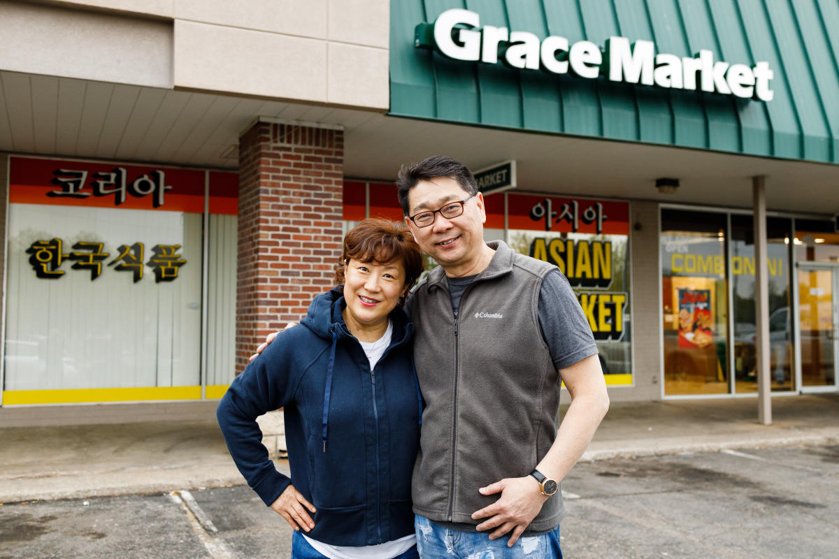 The owners of Grace Market pose for a photo in front of their store