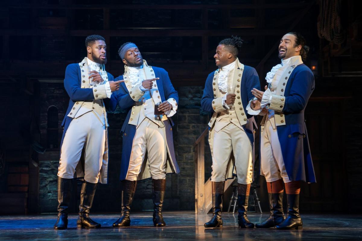 Four male members of the cast of Hamilton perform during a scene from the hit musical