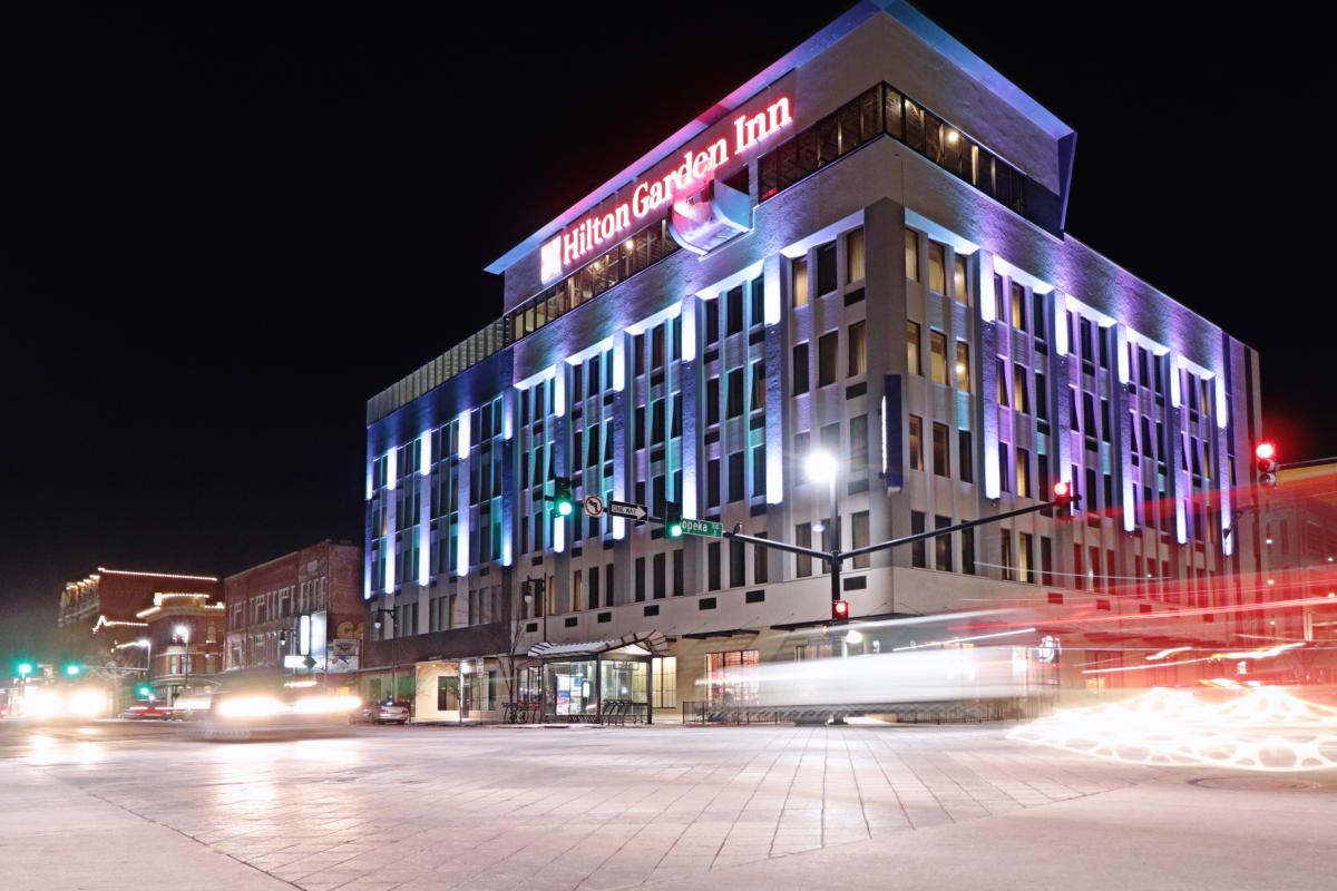 Hilten Garden Inn Downtown Wichita at night with traffic flowing in front of building