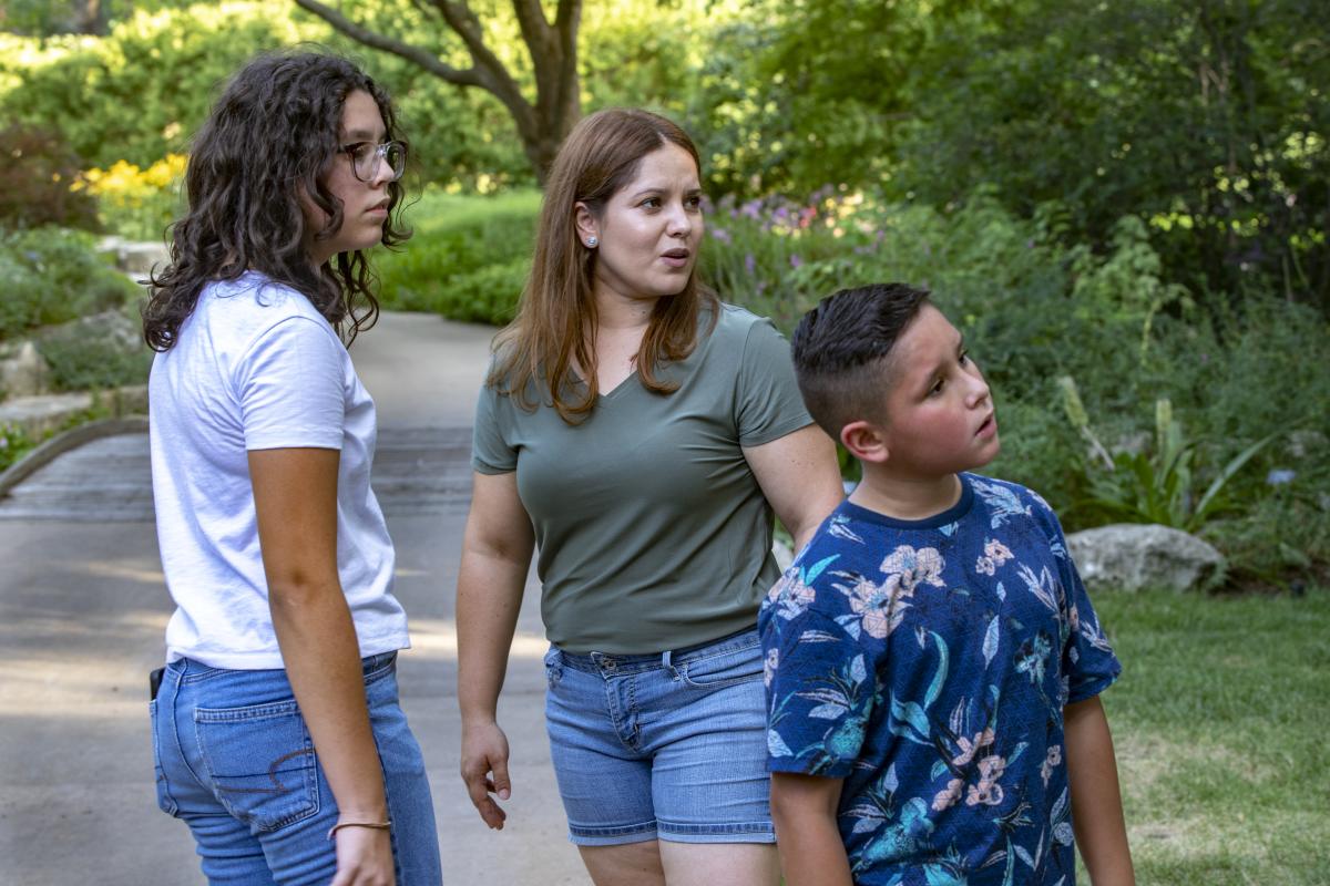 A Hispanic mother and her children walk in Botanica Wichita