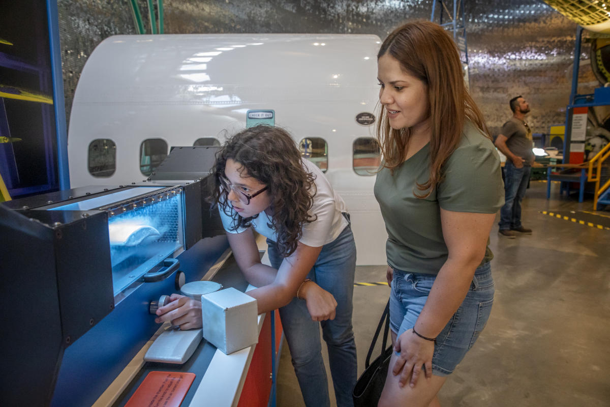 A Hispanic mother and daughter enjoy an exhibit at Exploration Place