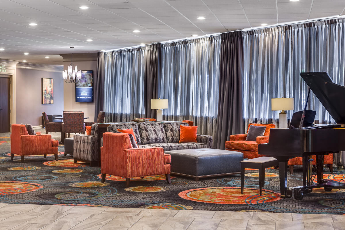 Bright chairs and sofas sit around a grand piano at the Holiday Inn East I-35 in Wichita