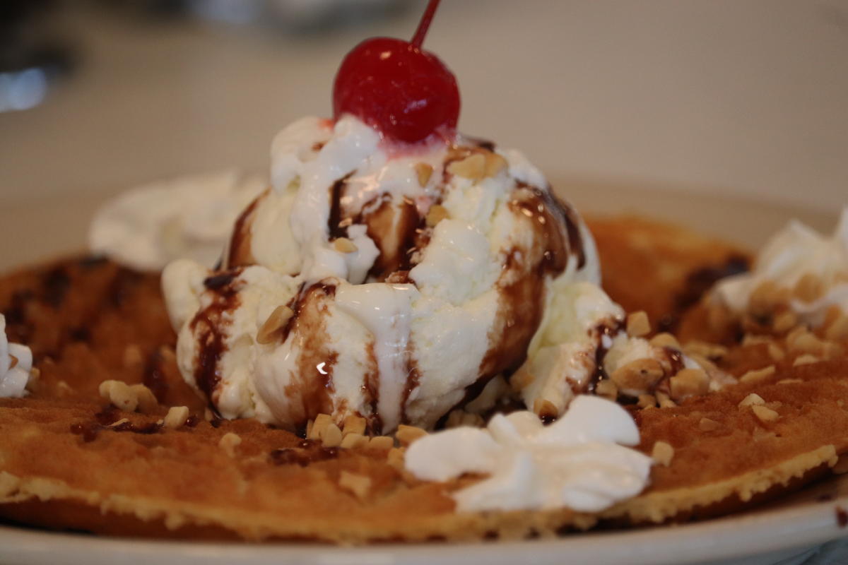 A waffle at Jimmie's Diner is topped with a scoop of ice cream, nuts, chocolate sauce, whipped cream and a cherry