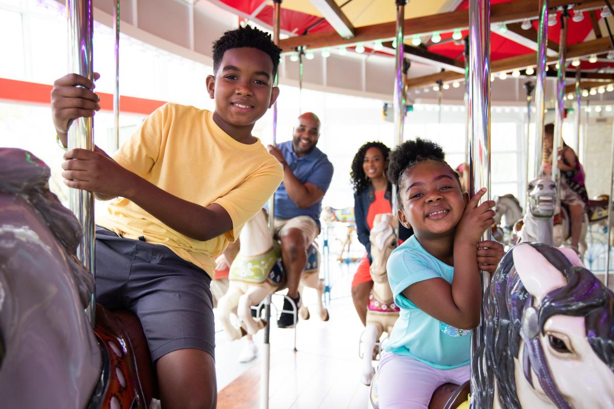 A young family rides the carousel at Botanica Wichita