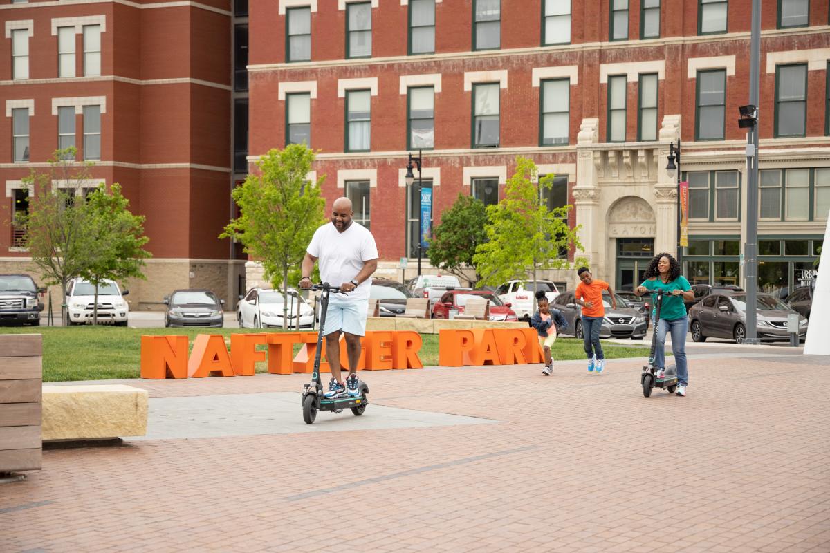 Family riding scooters at Naftzger Park