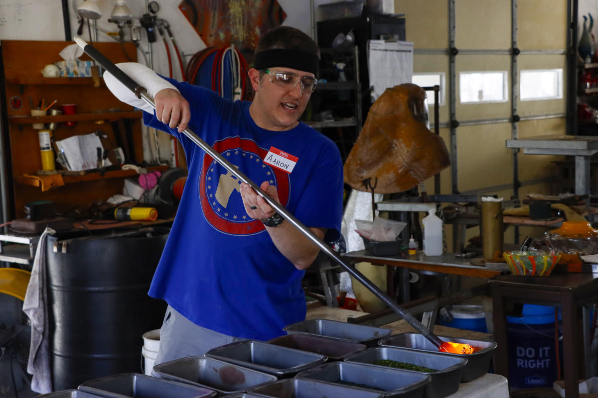 A man creates a piece of glass artwork at Karg Art Glass