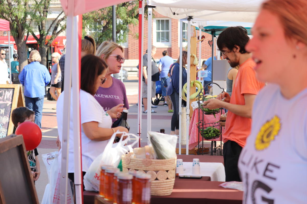 Patrons browse good at the Old Town Farmers Market in the Old Town District of Wichita