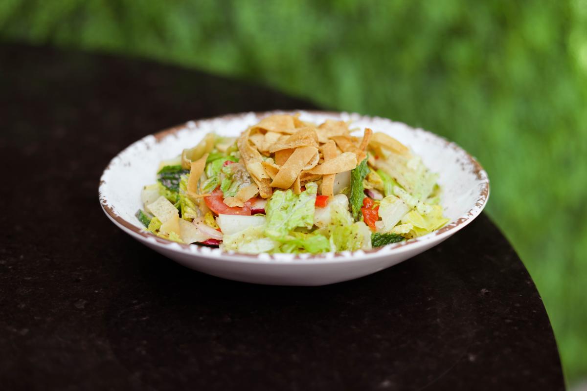A fattouch salad is served on a white dish at Meddys