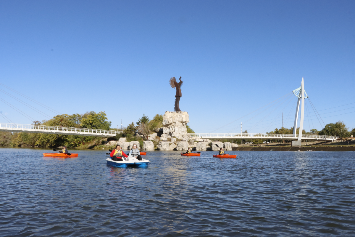 Several people explore the Arkansas River on pedal boats and kayaks rented from Boats and Bikes