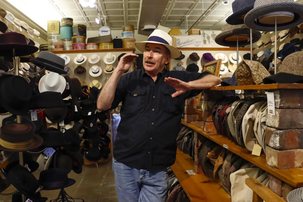 Hatman Jack's owner Jack Kellogg is photographed while being interviewed in front of hats he created