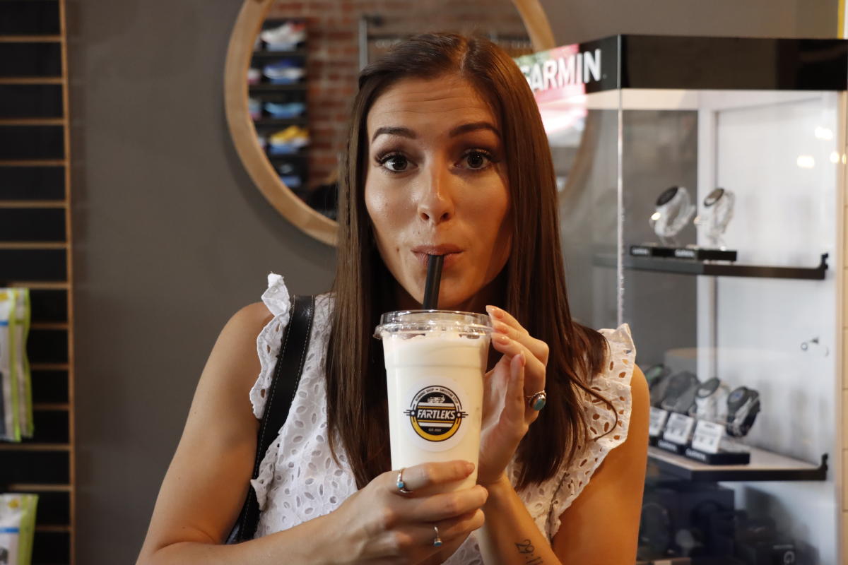 A young woman sips on a smoothie at Fartleks