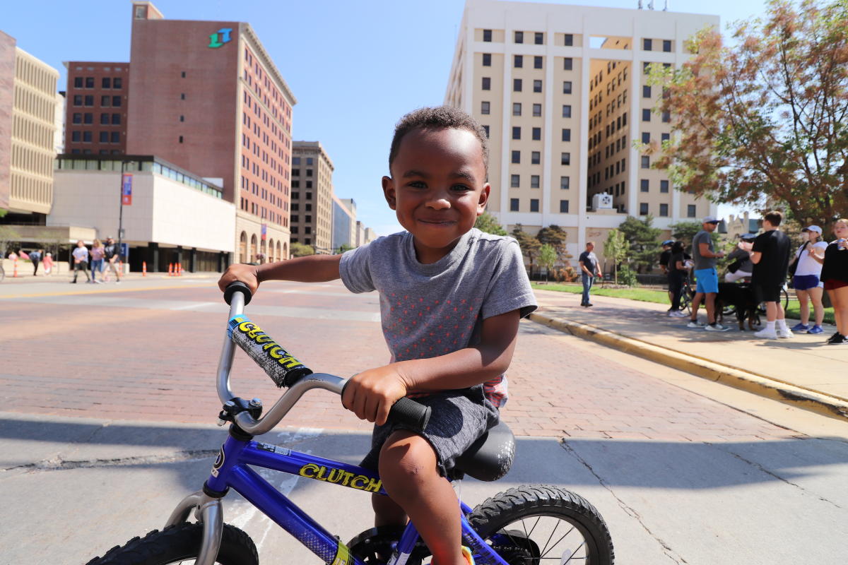 A small boy rides his bike in downtown Wichita