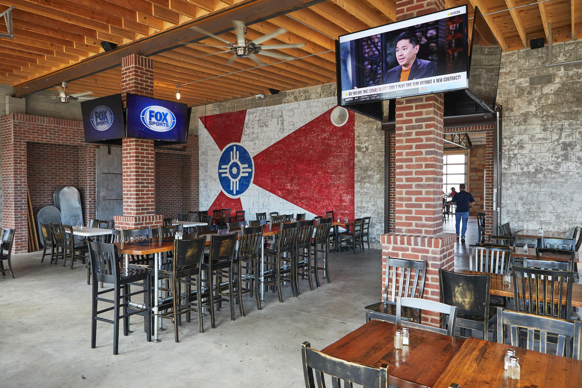 TV's are on over empty high-top tables at B&C BBQ in Wichita