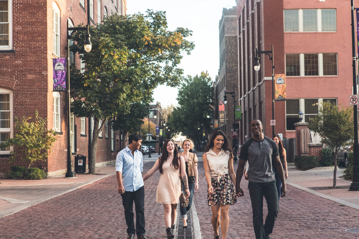 A group of young adults walks through Old Town in Wichita, KS