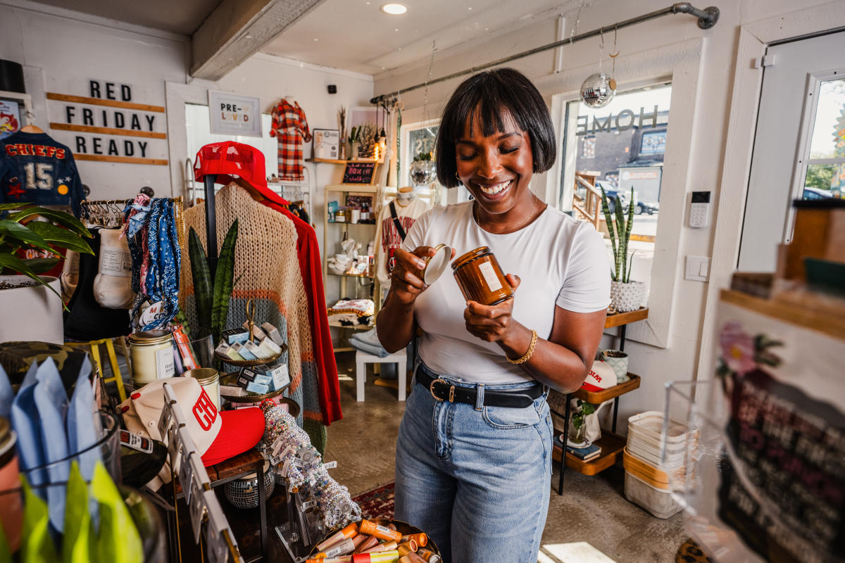 A woman looks at a candle while shopping at Clifton Collective in Wichita.