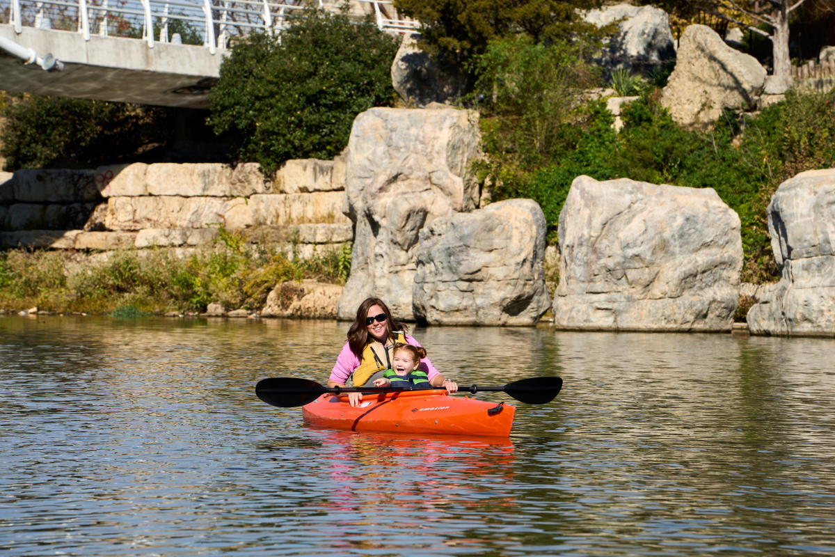 A mother kayaks in the Arkansas River with her young daughter