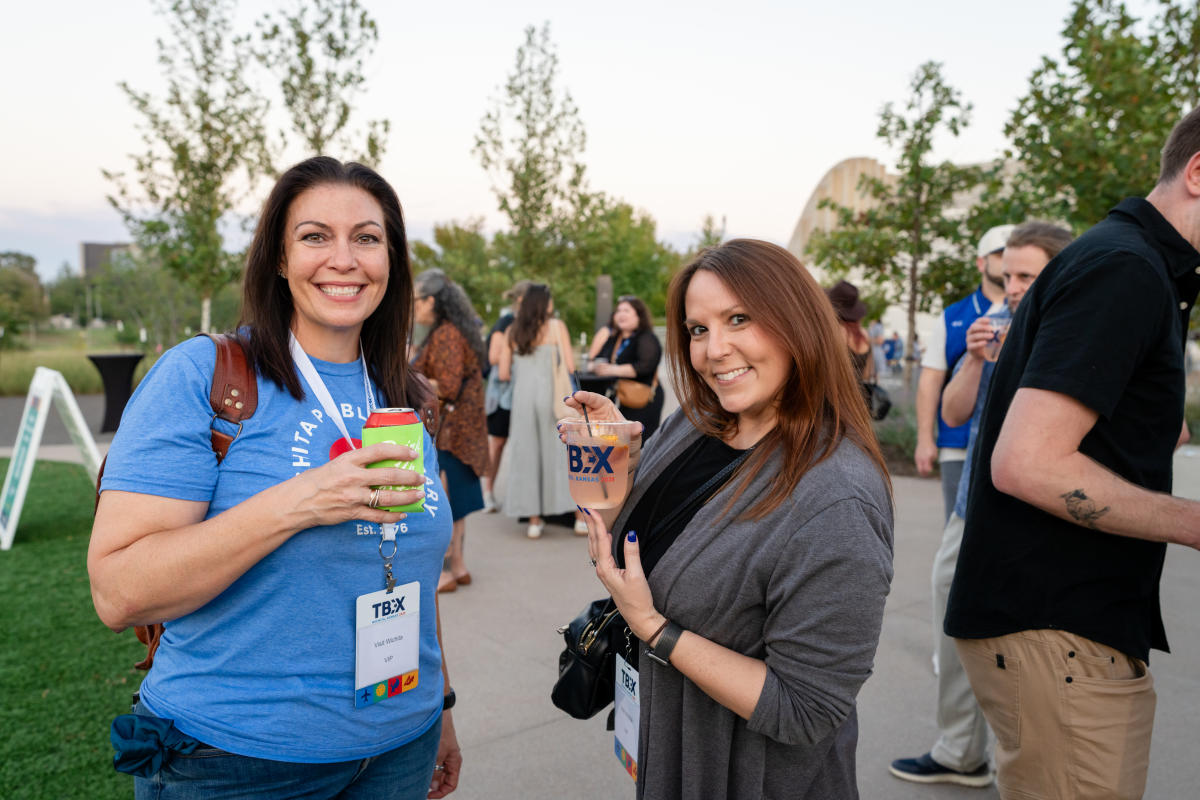 Two TBEX attendees smile for a photo outside during the opening night party at Exploration Place.