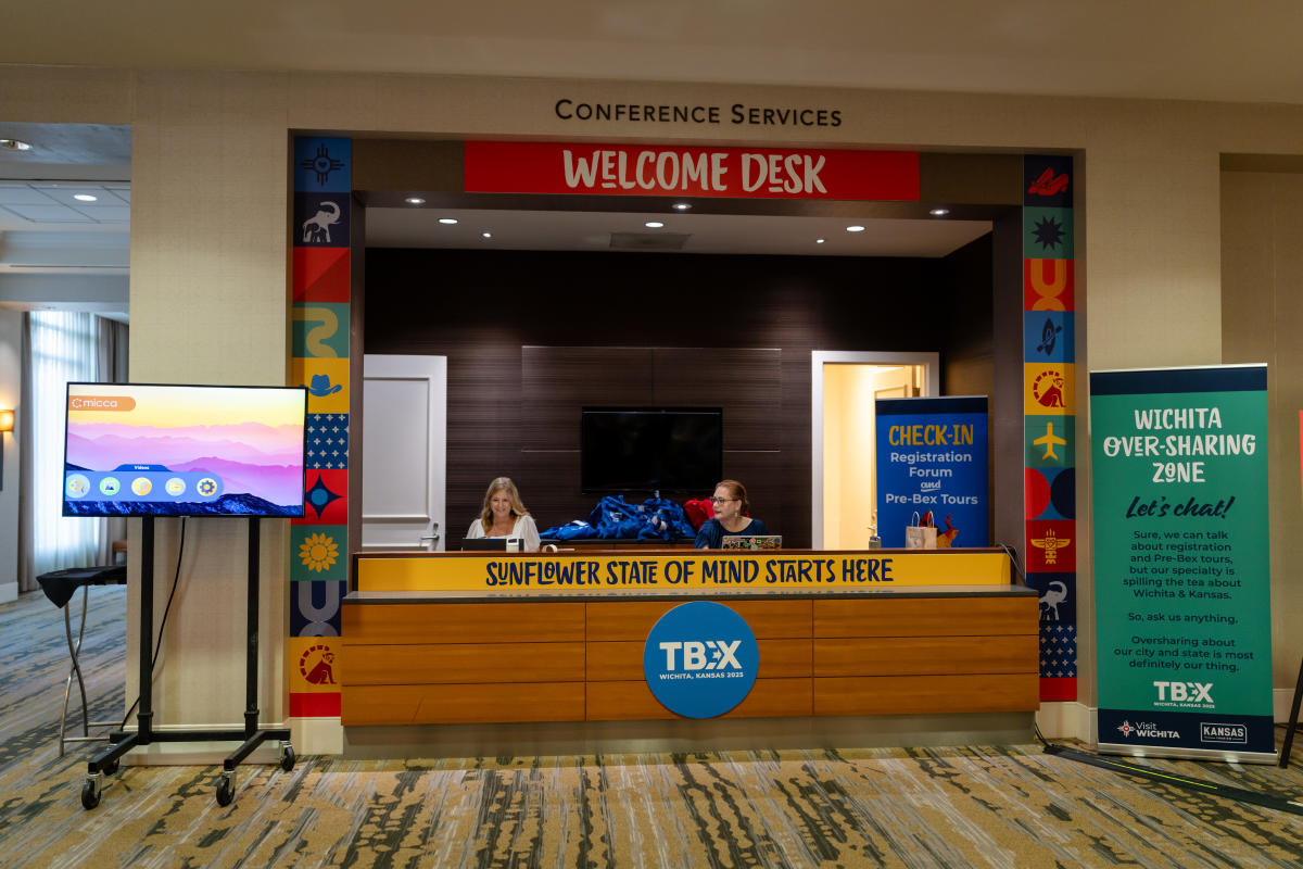 People welcome TBEX attendees at the Welcome desk during their conference at the Hyatt Regency Wichita.