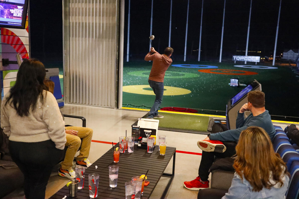 Visitors play golf at a rented bay at Topgolf Wichita