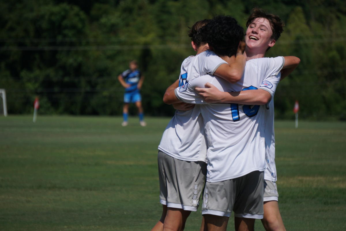 Two boys embrace during a soccer game