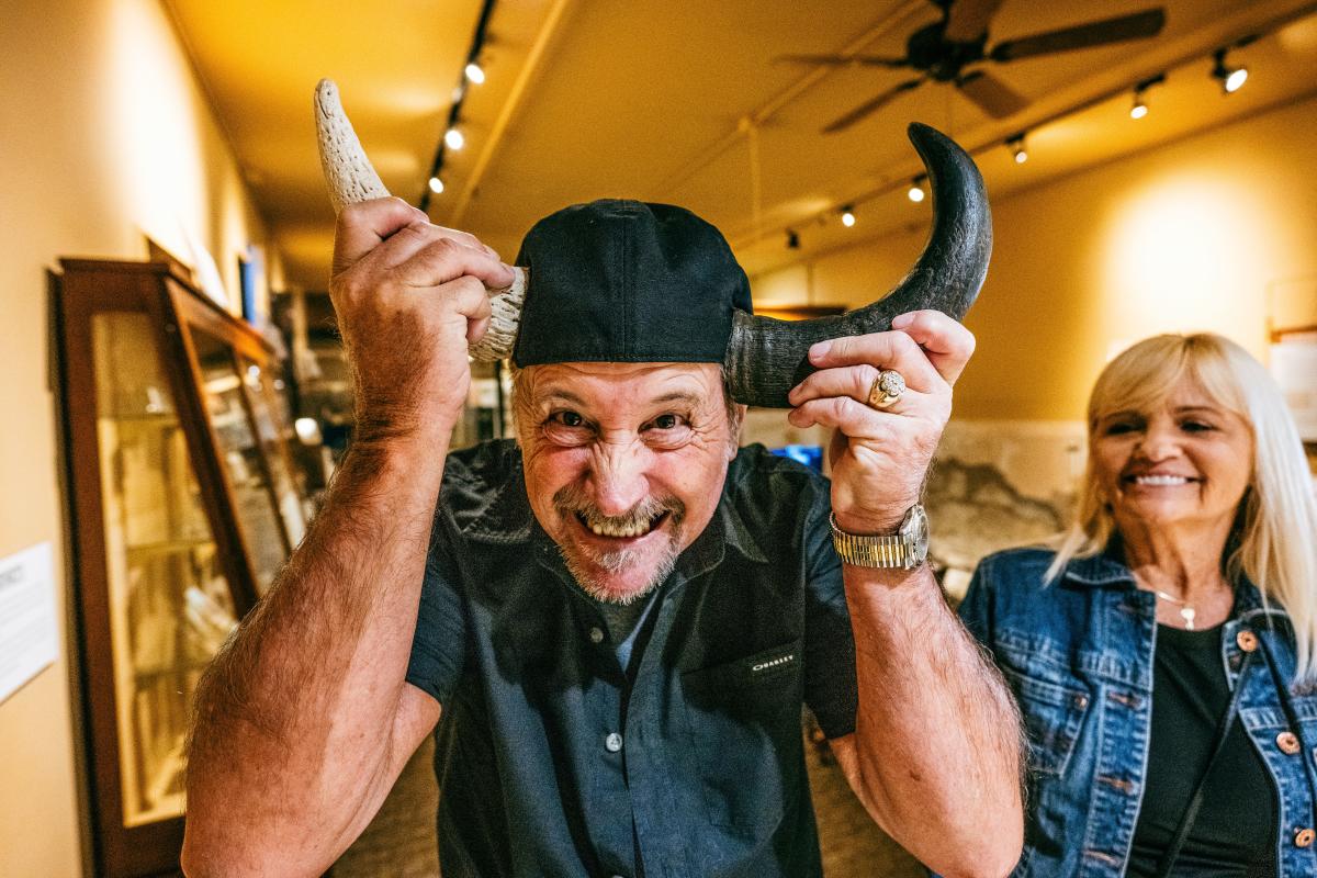 A man poses with horns while a woman smiles at him at the Wichita-Sedgwick County Historical Museum in Wichita.