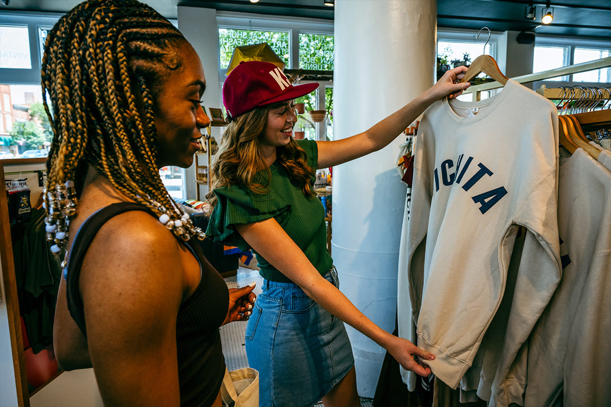 Two women shop and look at a Wichita sweatshirt at the Workroom