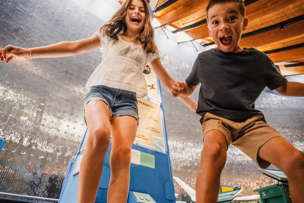 A boy a girl scream while smiling for the camera at Exploration PLace