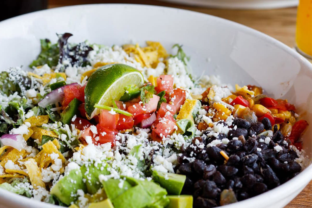 Crisp lettuce sits under avocadoes, black beans, corn, tomatoes, and corn strips to create the Avocado Chicken Salad at Homegrown