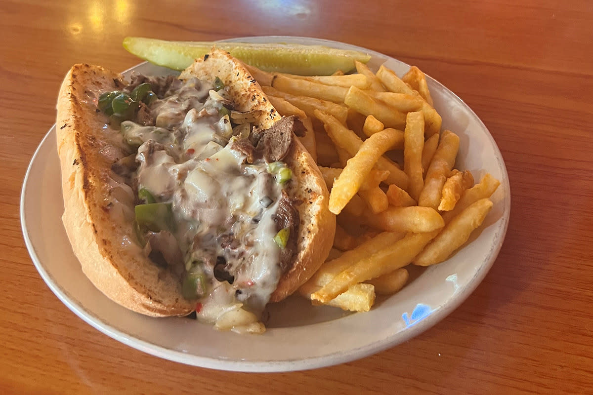 The Philly Cheesesteak sandwich is served with a side of fries at Pumphouse In Wichita, KS