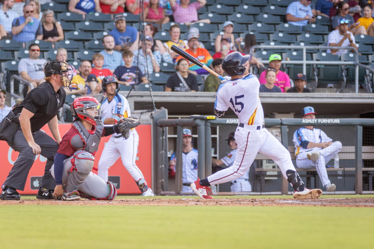 A baseball player swings to hit a ball during a Wind Surge game at Riverfront Stadium