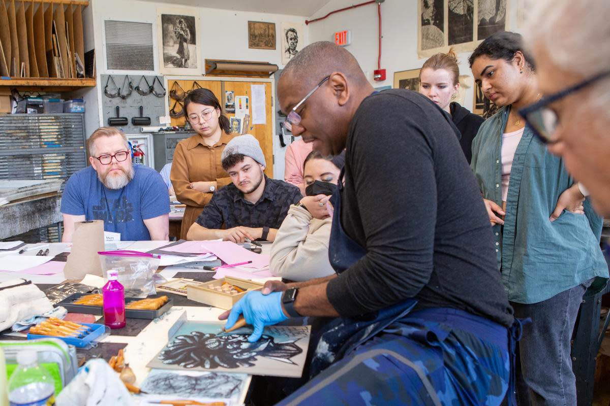 Man teaches class of students a drawing technique